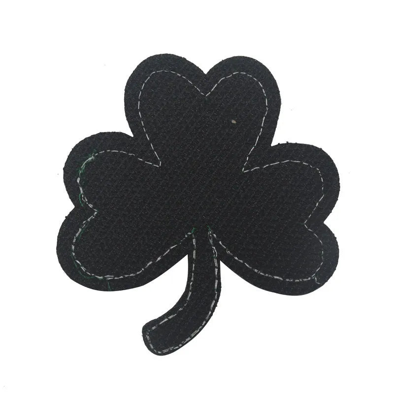 Outdoor embroidered fabric badge with Velcro strip backing on a green clover design.