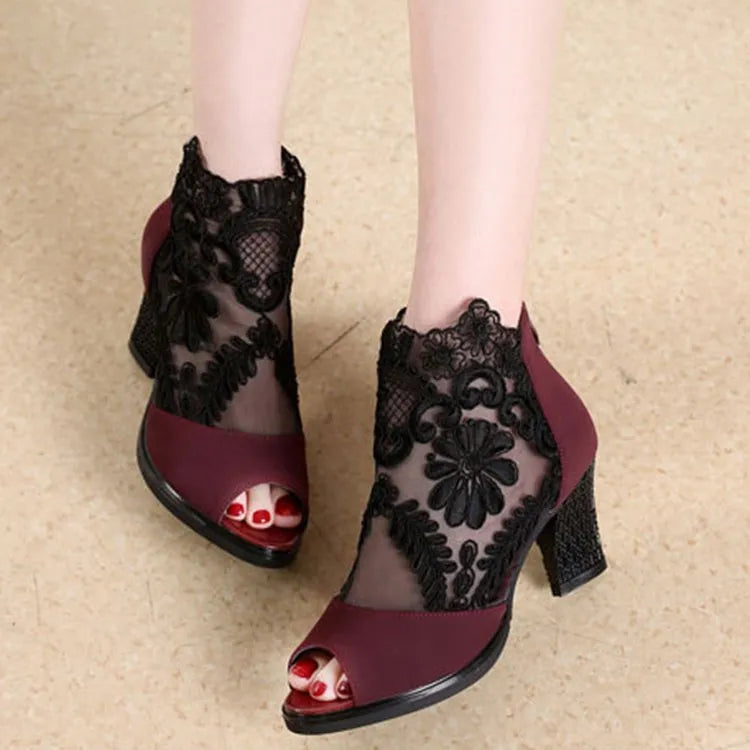 Black women's gladiator sandals with floral lace upper, high square heel, and a front zip closure.