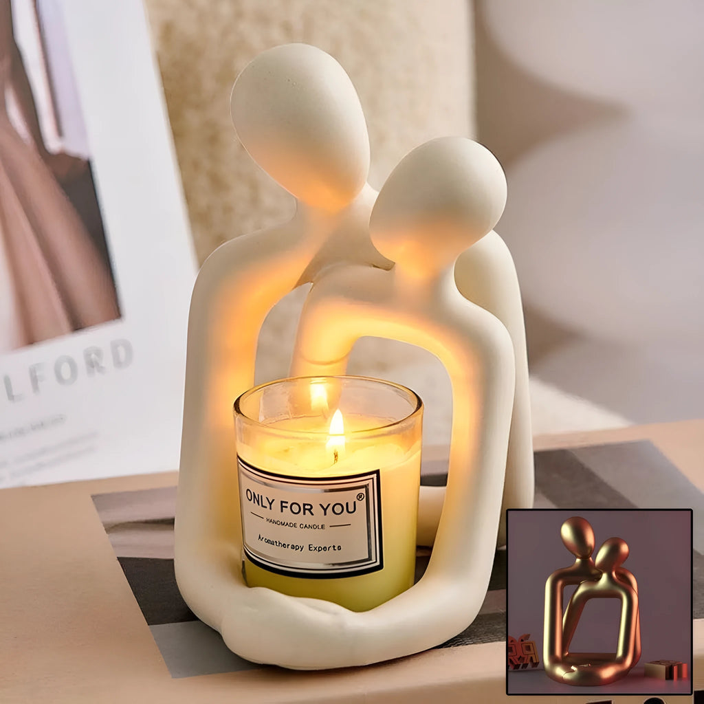 Modern loving couple resin statue in gold or milky white on a wooden shelf.