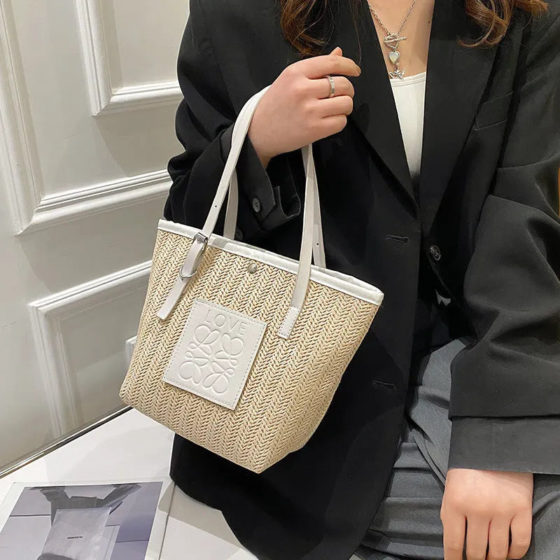 Straw woven women's shoulder bag in black showing European retro style with three-dimensional pocket