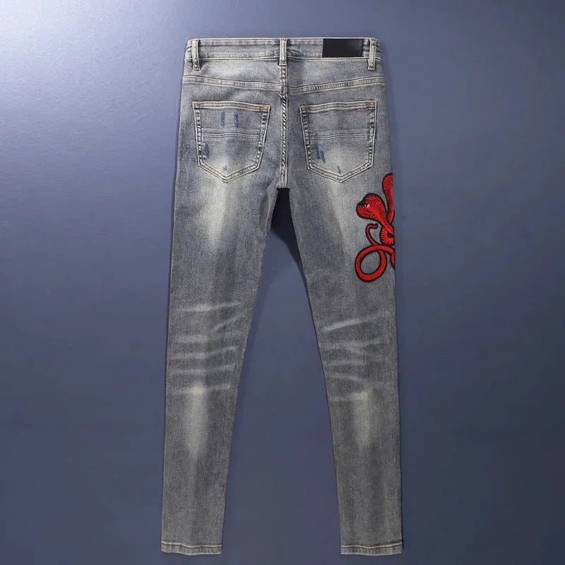 Men's slim fit old colour jeans with hole patch detail and embroidered branding on the leg