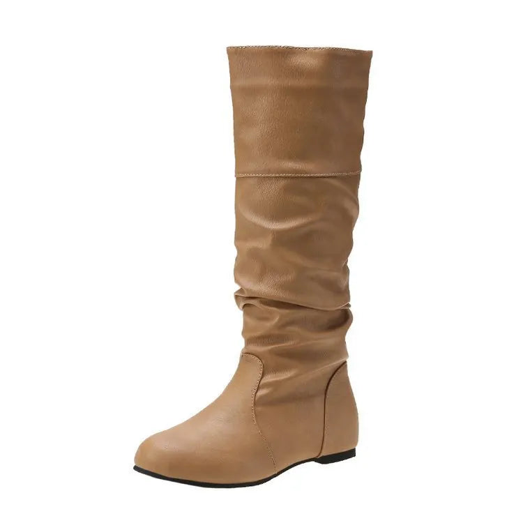 Women's flat slip-on long boots with round toe in black, shown on a foot.