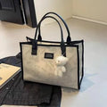 Women's black canvas tote bag with rhombus pattern print and shoulder strap