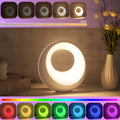 Small RGB colour changing night lamp with remote control on bedside table