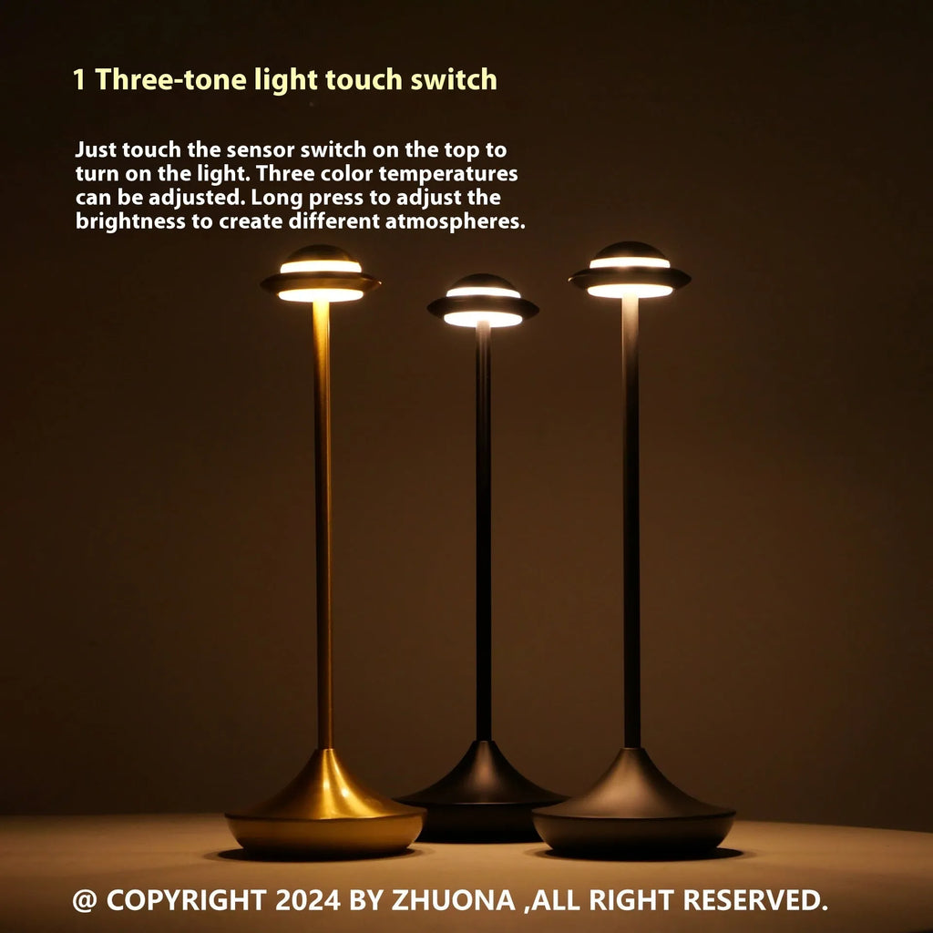 Gold UFO-shaped rechargeable table lamp with touch dimming controls on metallic surface