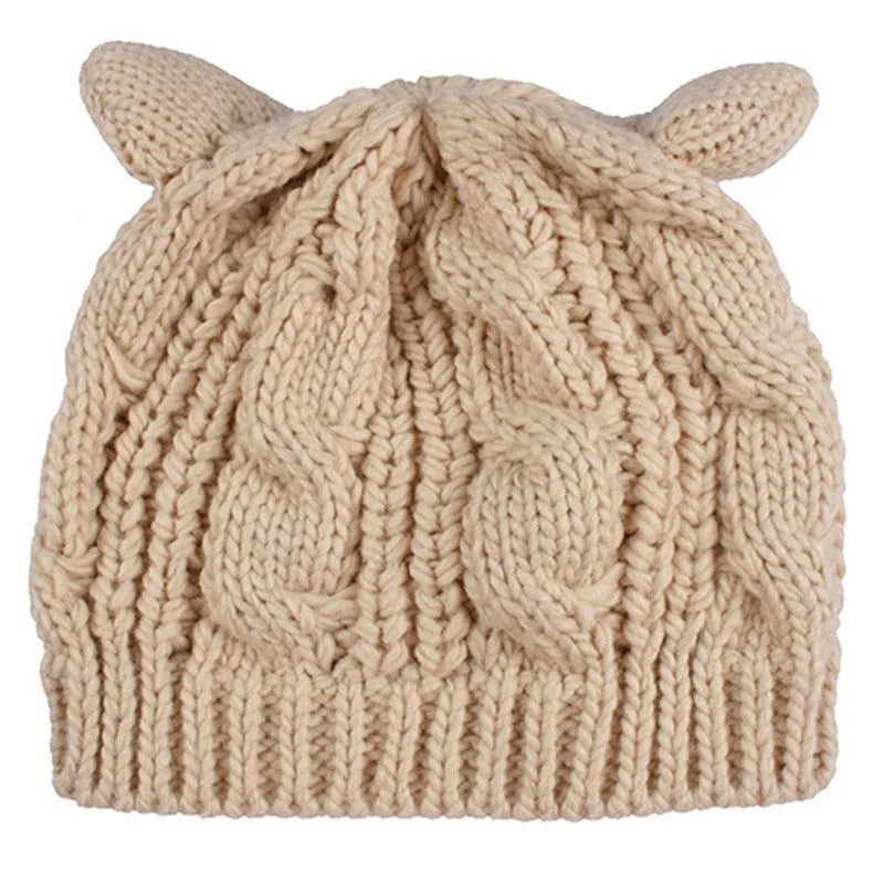Handmade red knitted beanie with 3D cat ears on a white background.