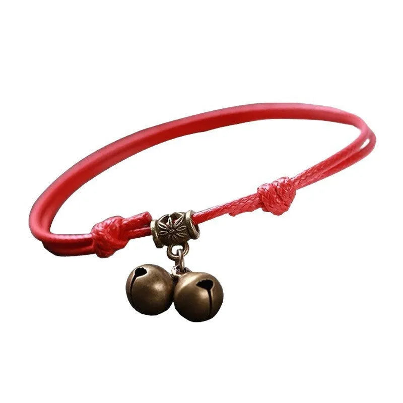 Close-up of a black nylon rope dog collar for small dogs, featuring a shining brass bell.