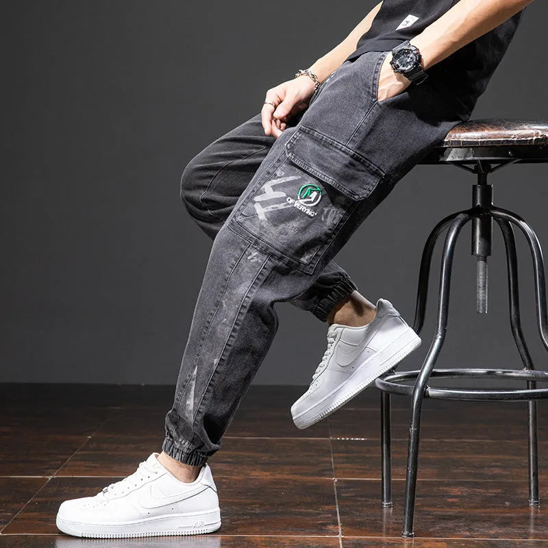 Man wearing loose fit blue cargo jeans with a straight leg and skinny ankle opening.