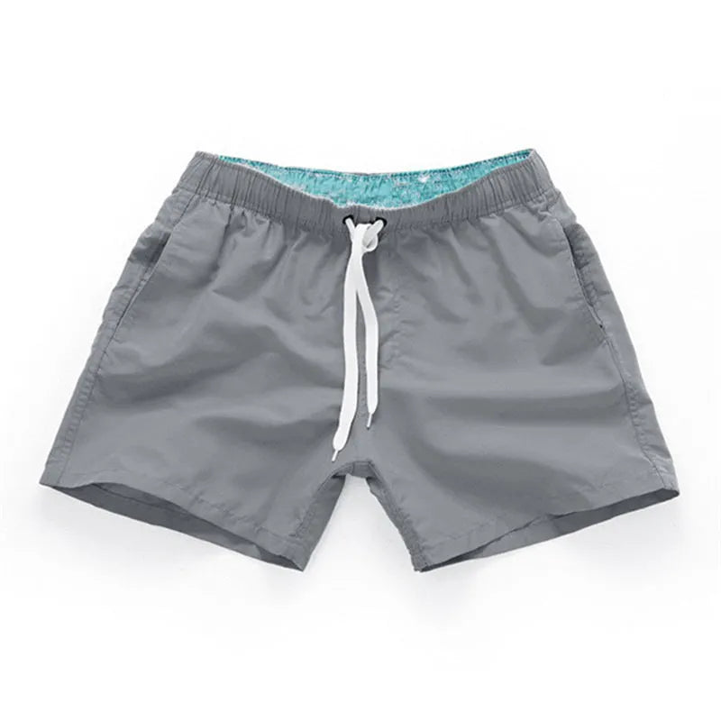 Men's straight-leg beach shorts in polyester fabric shown in a solid colour, laid flat.