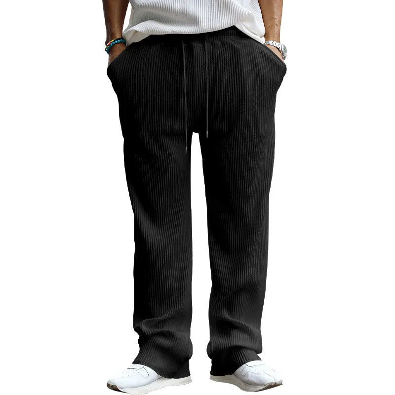 Man wearing loose-fit, high-waist, straight-leg casual trousers in a striped pattern.