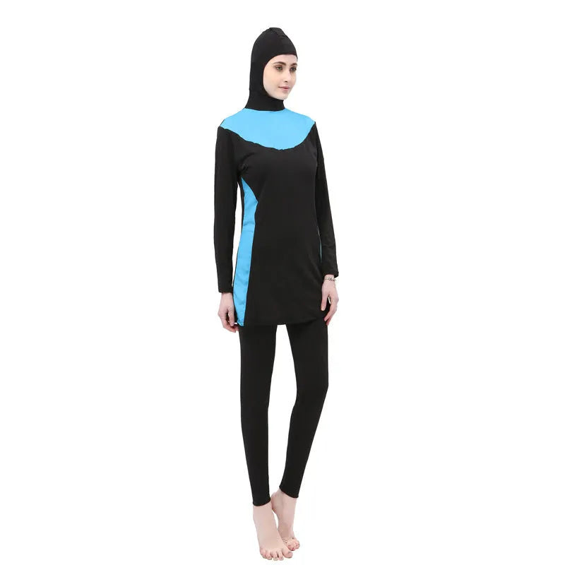 Women's black long sleeve hooded swimsuit with separate pants, shown on a model.