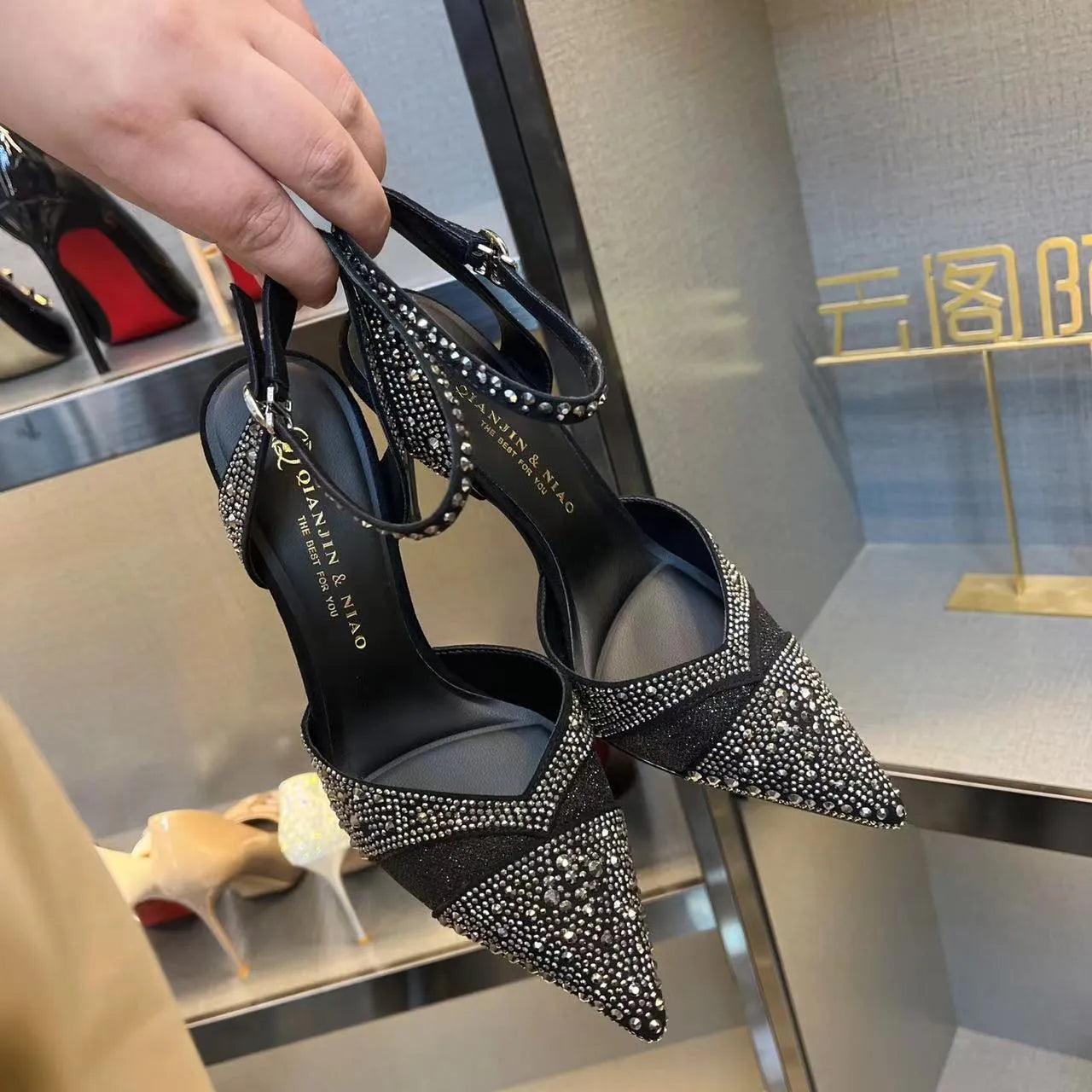 Women's black hollow high heels with red sole and pointed toe on a stiletto heel
