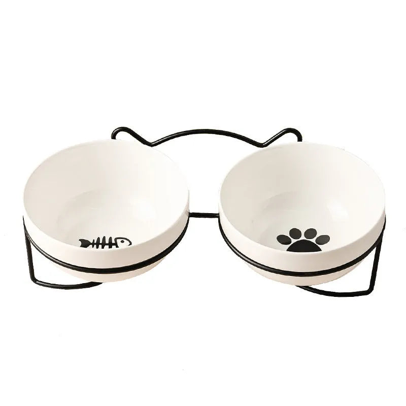 White ceramic cat bowl with decorative pattern sitting in a black iron frame stand.