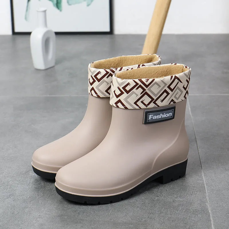 Women's mid-calf PVC rain boot in black with a low heel on a white background.