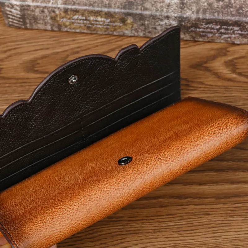 Retro brown floral embossed tri-fold leather wallet open to show interior compartments.