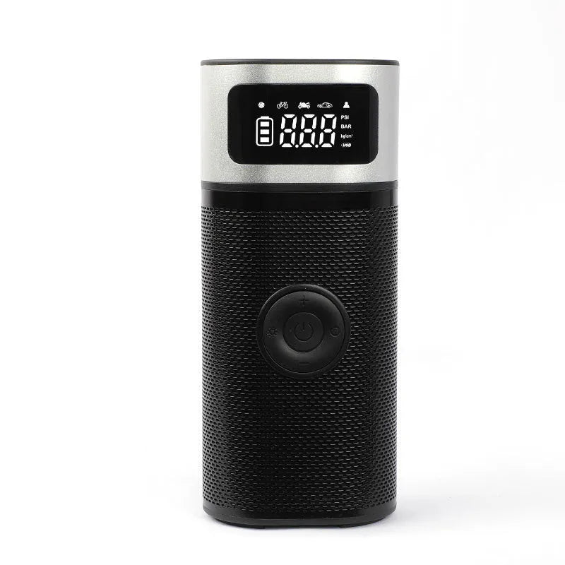 Black portable wireless smart air pump with display, charging cable and nozzle attachments on a dark surface.