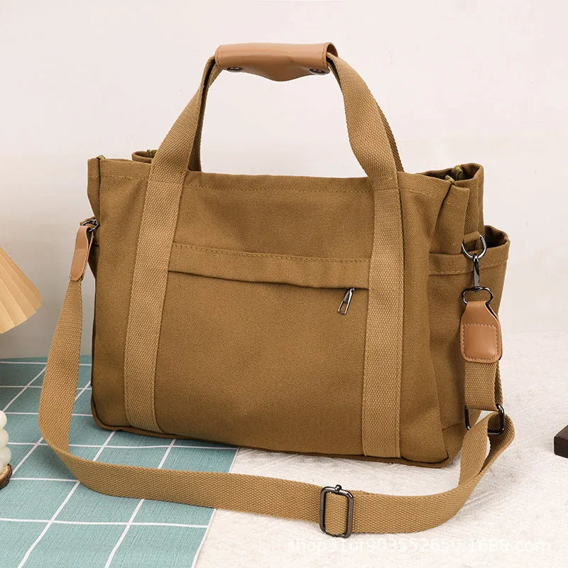Large khaki canvas tote bag for women with open top showing internal laptop and camera pockets