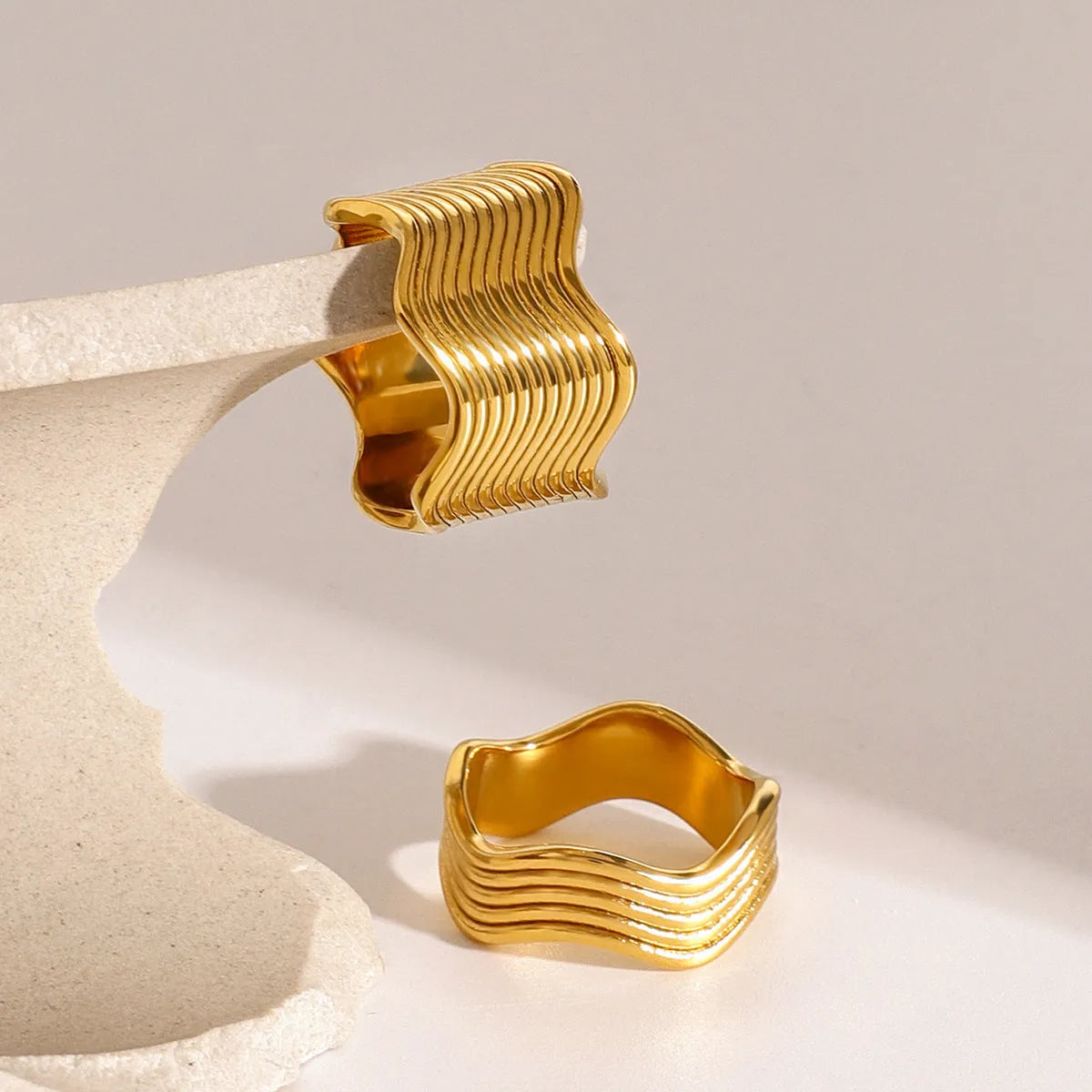 Stainless steel geometric wave ring for women with a wide surface area and electroplated finish.