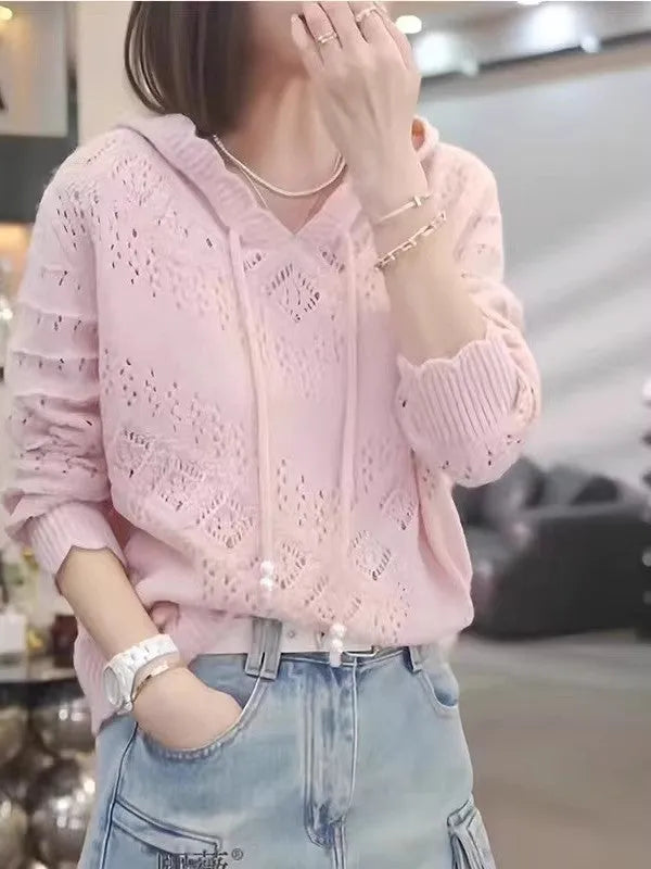Woman wearing a light blue, hooded crochet longsuit undershirt with a hollow knit pattern and long sleeves.