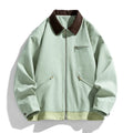 Man wearing a mint green retro workwear jacket with dark contrast lapels and side pockets.