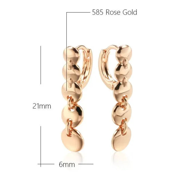 A pair of long gold-colour retro earrings with a woven round circle design made from copper.