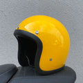 A cement grey retro-style motorcycle half helmet with a floral pattern on the side, showing its open-face design.