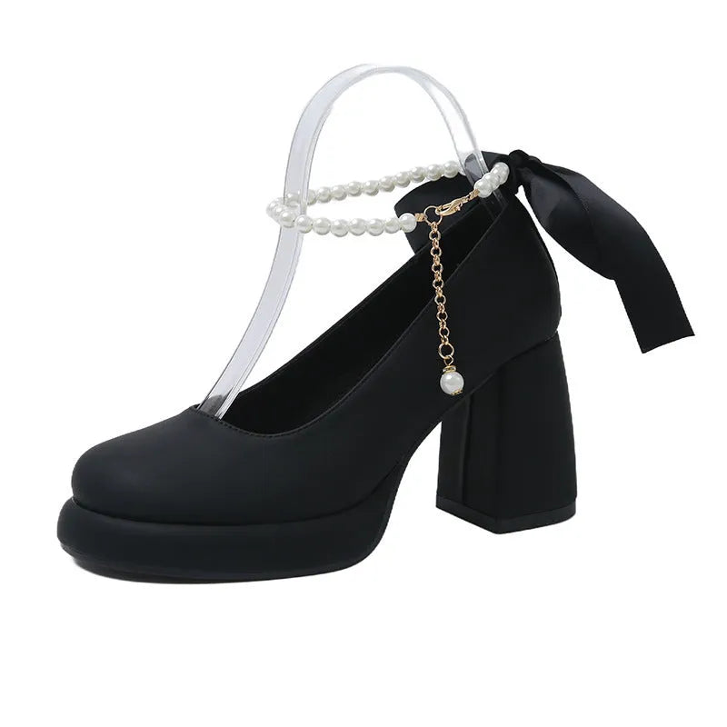 Women's beige Mary Jane shoes with a chunky heel and an ankle-strap buckle on a round toe.