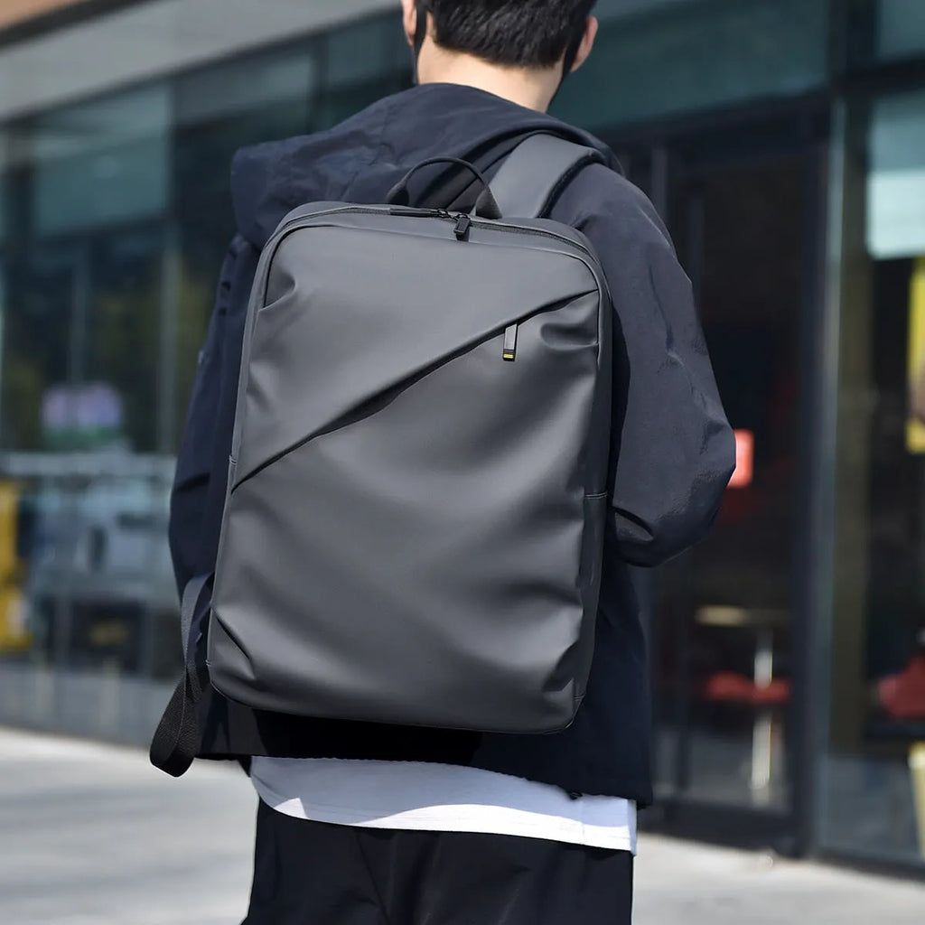 Men's large waterproof PU backpack in black, blue, or grey showing sewing thread details