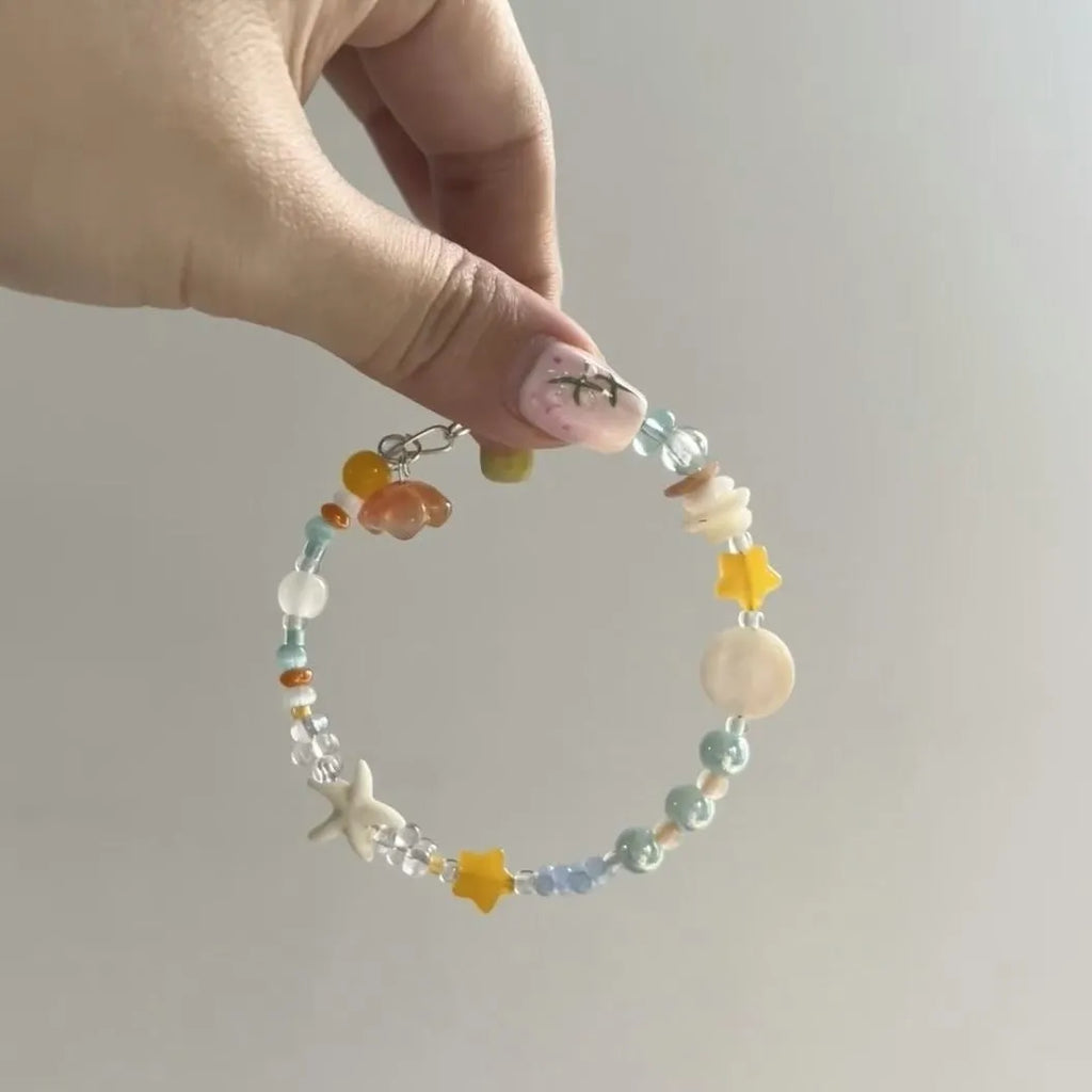 Orange diamond-shaped women's bracelet with round details on a mixed material and alloy band.