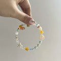 Orange diamond-shaped women's bracelet with round details on a mixed material and alloy band.