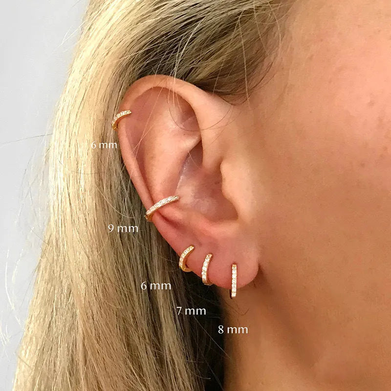 Circle zircon perforated stud earrings in gold, rose gold, and silver colour on a white background.