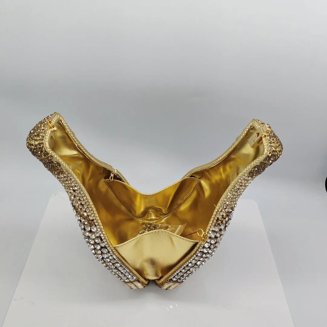 Gold rhinestone champagne bottle shaped evening clutch bag with wrist strap on a dark background.