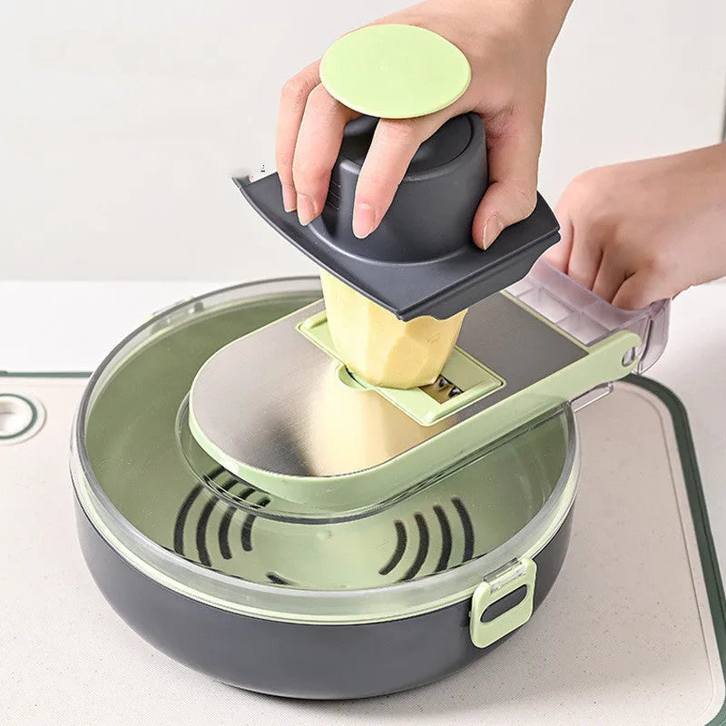 Grey and white multifunctional vegetable cutter set with eight stainless steel knives and accessories on a countertop.