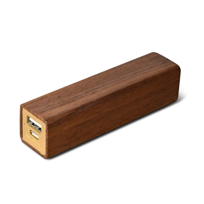Brown black walnut wood portable power bank showing size next to a charging cable