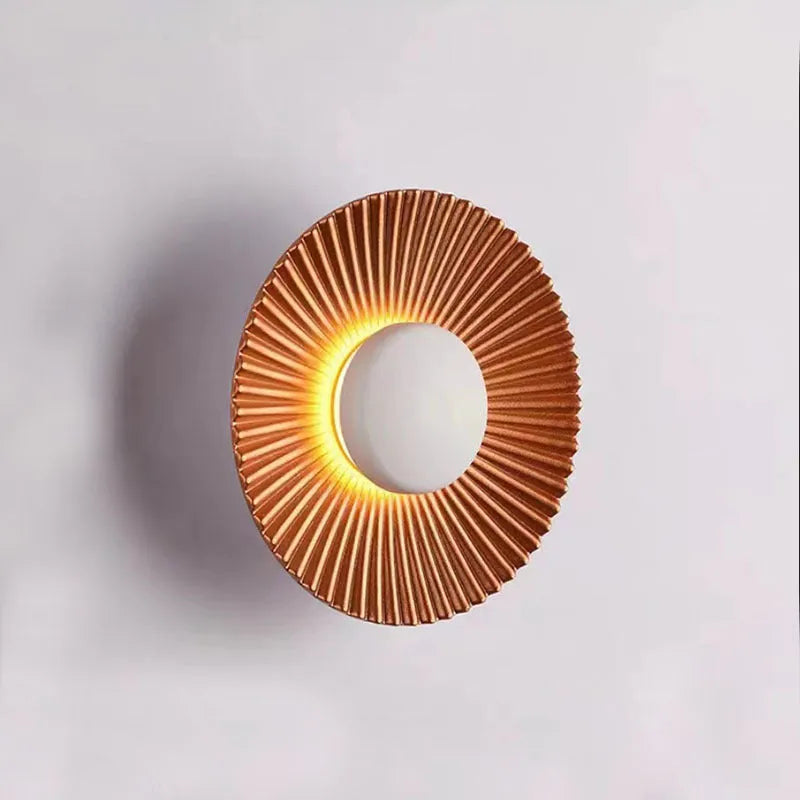 Round aluminium wall lamp mounted on a wall, showing a white and gold two-tone finish.