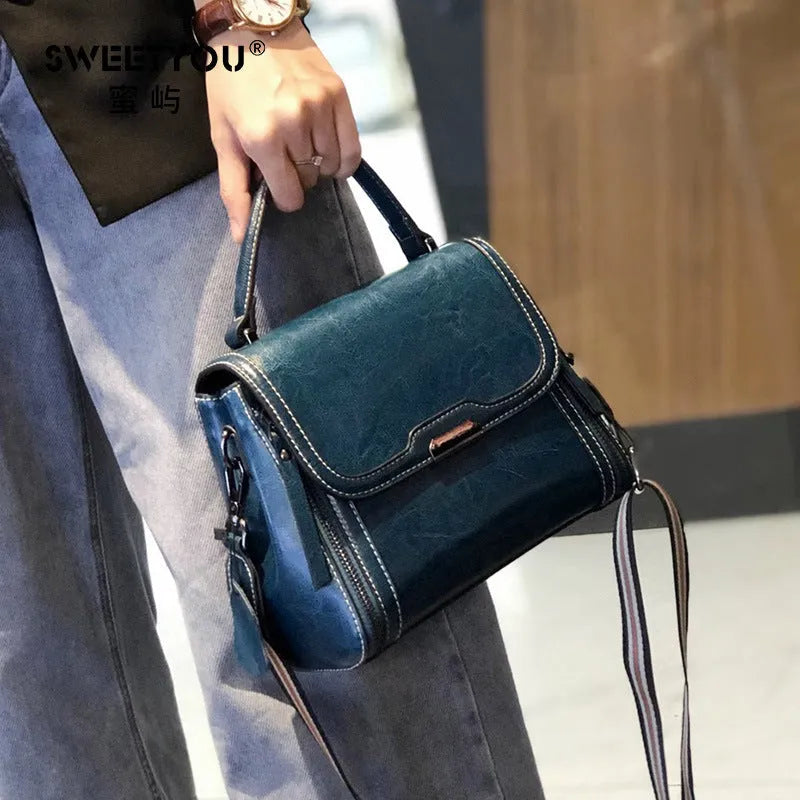 Women's brown genuine leather messenger bag with retro styling and multiple internal pockets