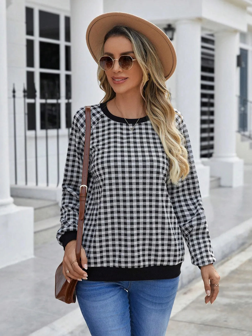 Black plaid and stripe pattern pullover sweater with long sleeves on mannequin