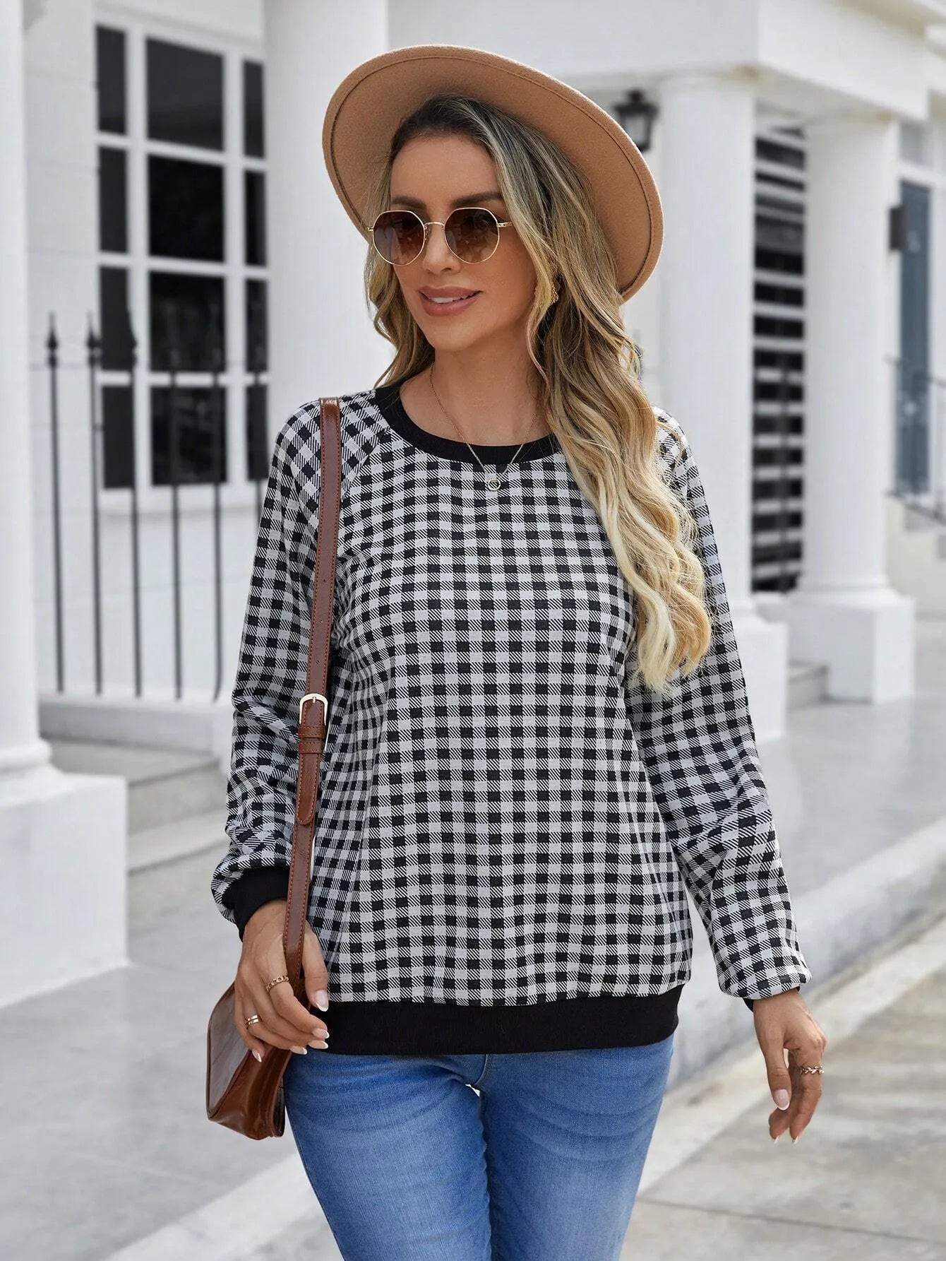 Black plaid and stripe pattern pullover sweater with long sleeves on mannequin