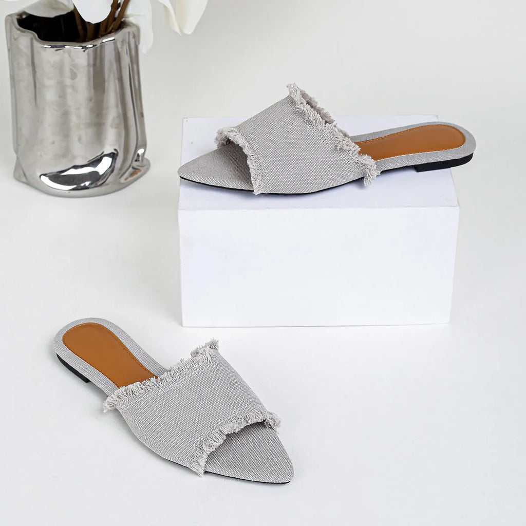 Women's denim casual flat slippers with a tassel detail in multiple colour options.