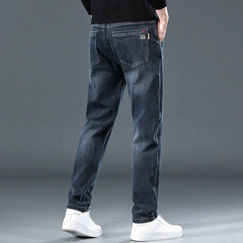 Man wearing slim straight blue grey casual trousers with a loose thin fit and zip fly.