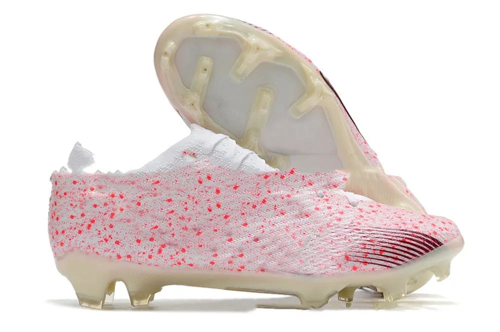 Men's low-top knitted football shoes with white/blue colourway, showing FG studs on rubber outsole and lace-up front.