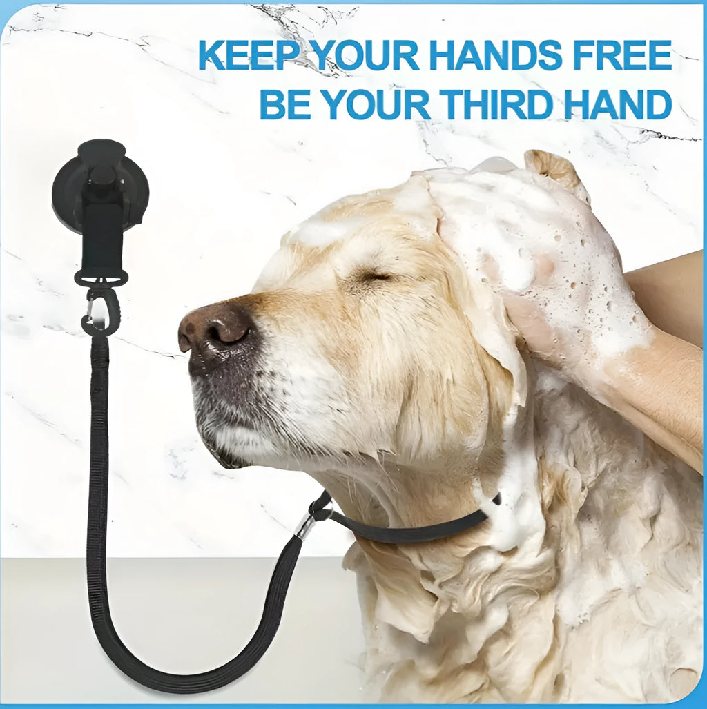 Pet bathing restraint tool with large suction cups, handcuffs, and a connecting rope on a bathroom tile background.
