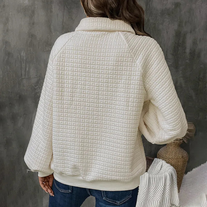 Women's beige textured polo collar long sleeve sweater laid flat.