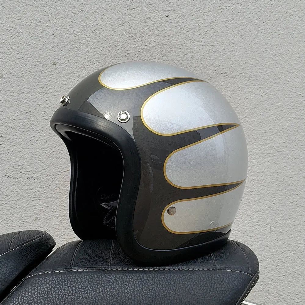 A cement grey retro-style motorcycle half helmet with a floral pattern on the side, showing its open-face design.
