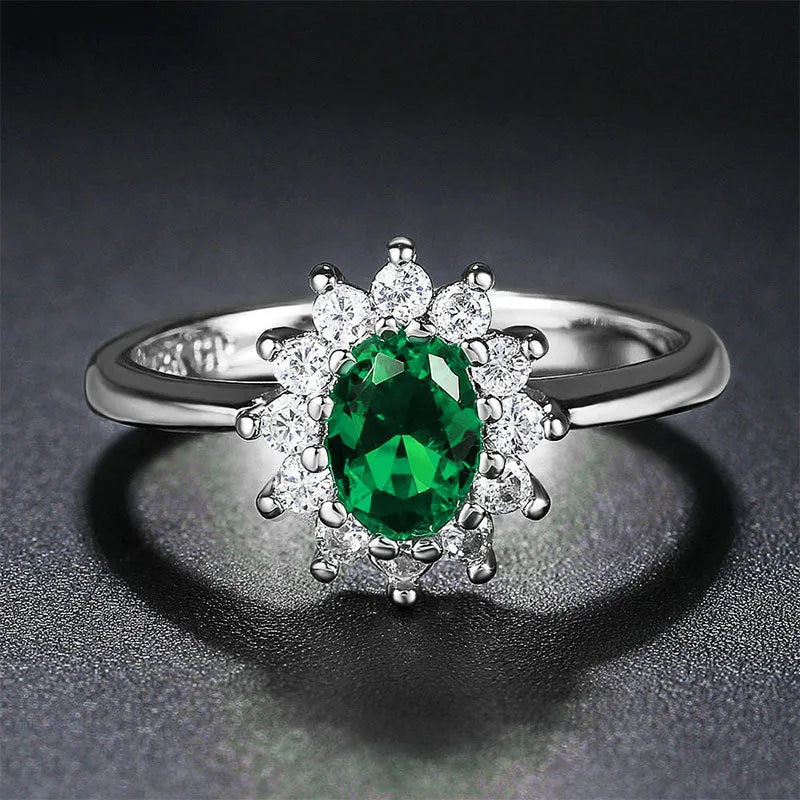 Copper women's ring with floral zirconium design in green, blue, or red on a model's hand.