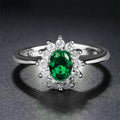 Copper women's ring with floral zirconium design in green, blue, or red on a model's hand.