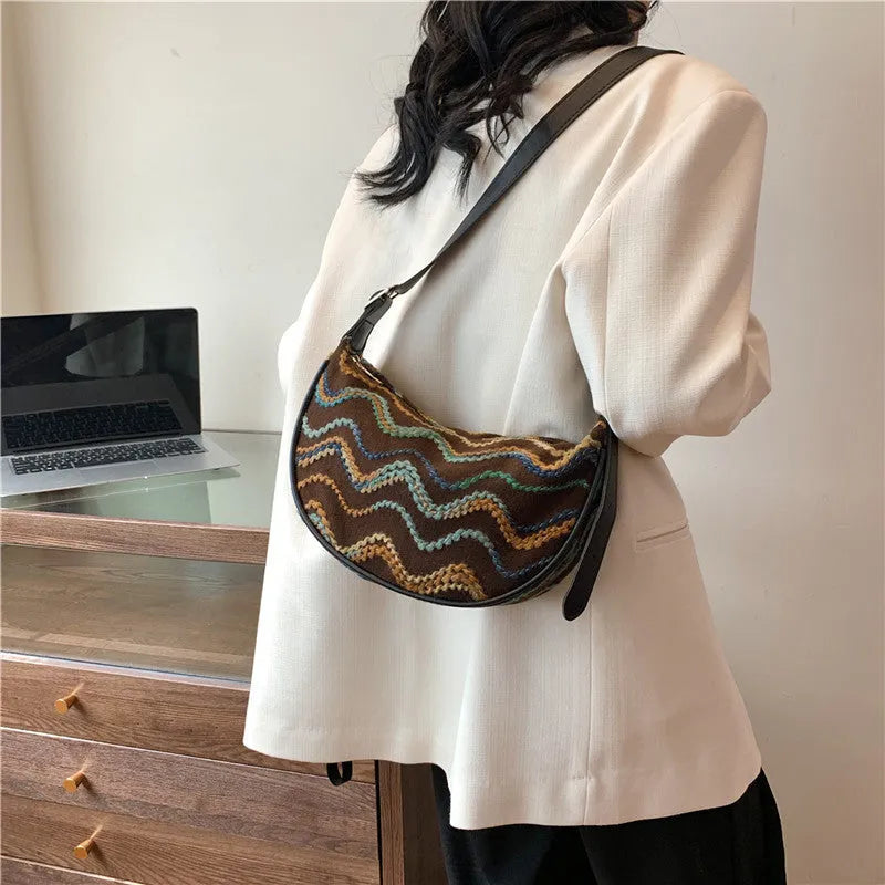 Women's woven straw crossbody bag showing internal phone pocket and file compartment