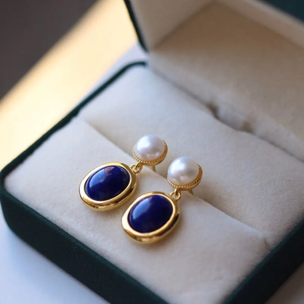 A pair of simple silver earrings with blue lapis lazuli pearls and auspicious patterns.