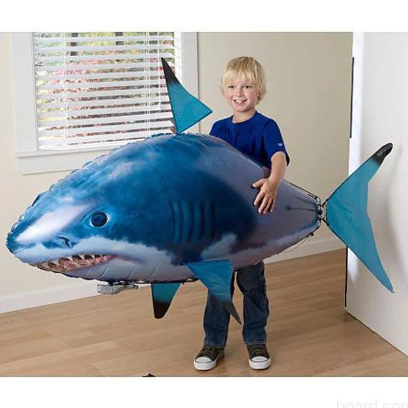 Large remote control inflatable shark balloon floating indoors with remote.
