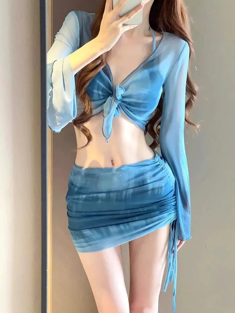 Women's blue four-piece bikini set with high-waist briefs, backless top, and coordinating skirt